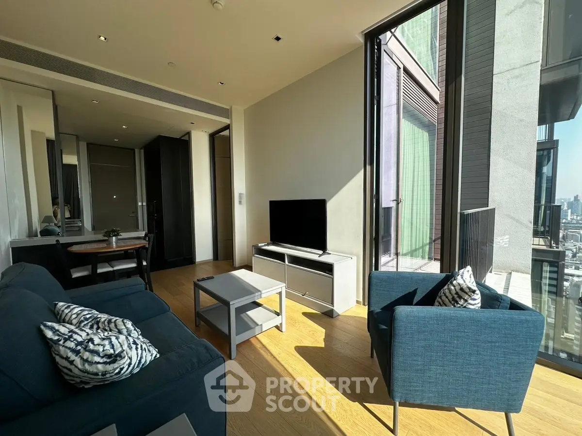 Modern living room with large windows and stylish furniture in a high-rise apartment.