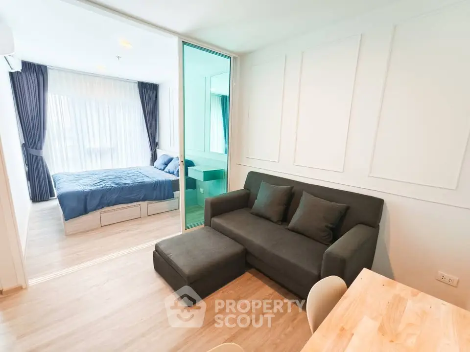 Modern studio apartment with cozy living area and bedroom, featuring stylish decor and natural light.