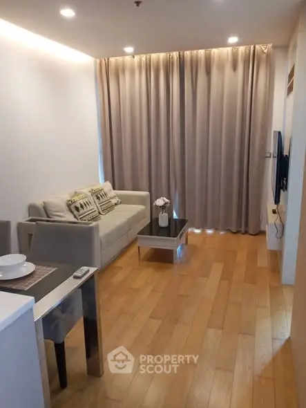 Cozy modern living room with wooden flooring and elegant curtains