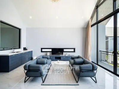 Luxurious modern living room with sleek furniture and large windows offering natural light.