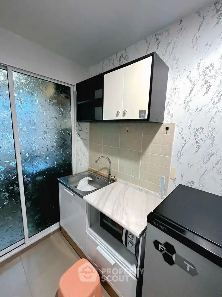 Modern compact kitchen with marble countertop and sleek cabinetry