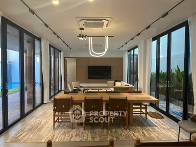 Luxurious modern living room with elegant dining area and floor-to-ceiling windows.