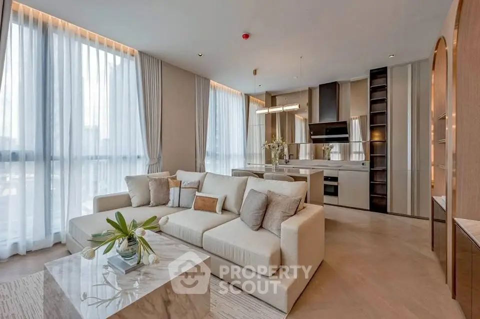 Luxurious open-plan living room with modern kitchen and elegant decor in a high-end apartment.