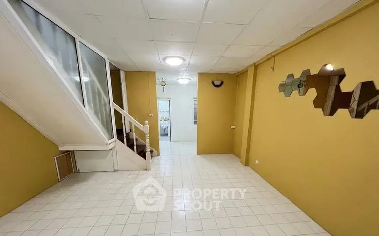 Spacious interior with unique wall decor and staircase, ideal for modern living.
