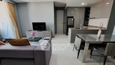 Modern open-plan living room with sleek kitchen and stylish dining area in a contemporary apartment.