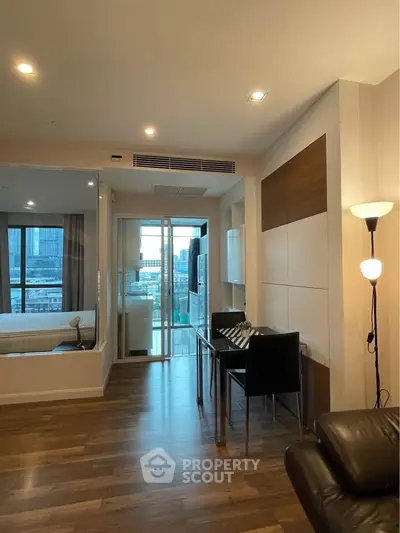 Modern apartment interior with wooden flooring and city view balcony.