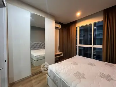 Modern bedroom with large window and mirrored wardrobe in stylish apartment