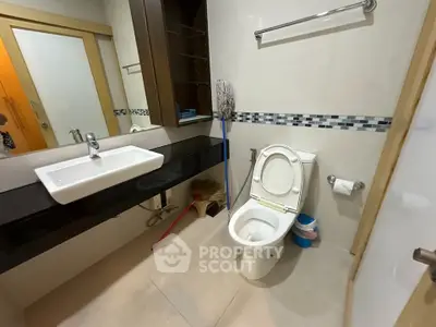 Modern bathroom with sleek fixtures and stylish tile accents, featuring a spacious vanity and contemporary toilet.