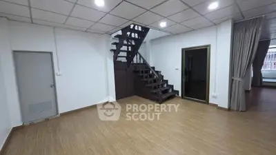 Spacious modern living room with wooden flooring and stylish staircase