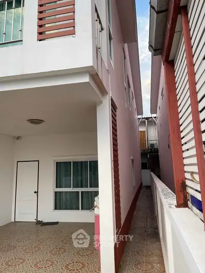 Charming two-story house with tiled patio and modern design elements.