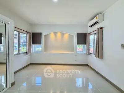 Bright and spacious living room with large windows and modern air conditioning unit.