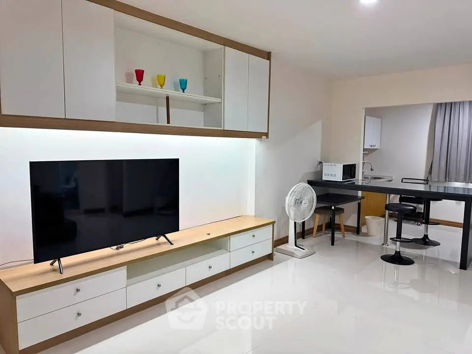 Modern living room with sleek TV unit and open kitchen layout