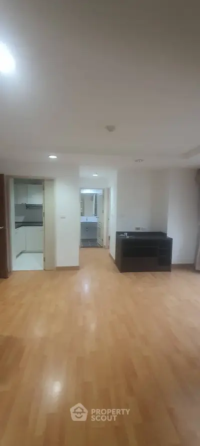 Spacious open-plan living area with wooden flooring and modern kitchen