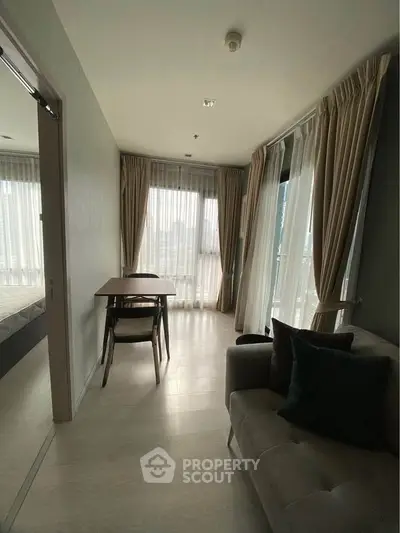 Cozy living room with natural light and elegant curtains in modern apartment.