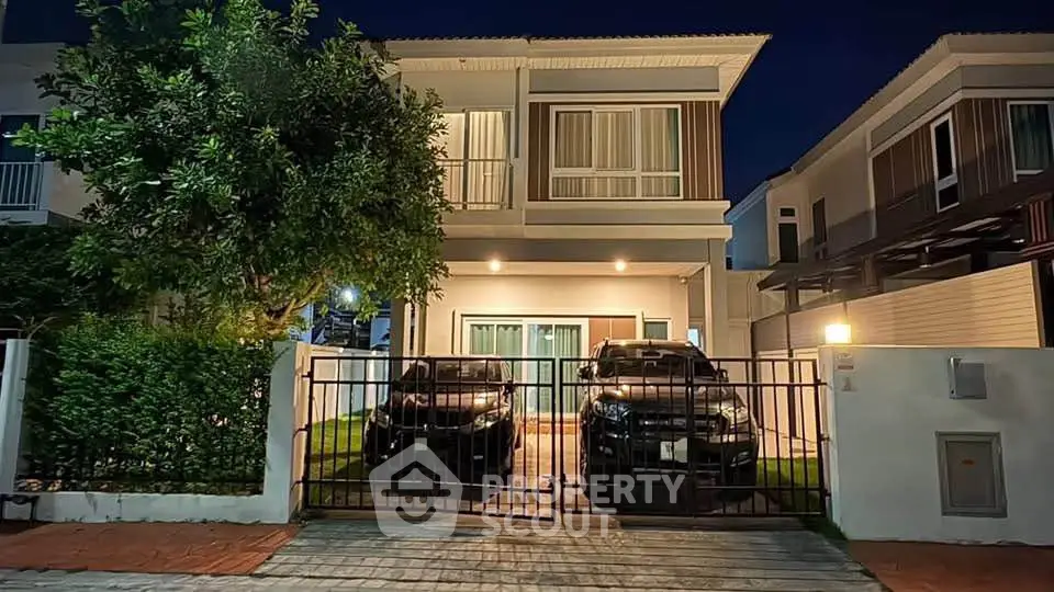 Stunning two-story modern home with gated driveway and lush greenery, perfect for family living.