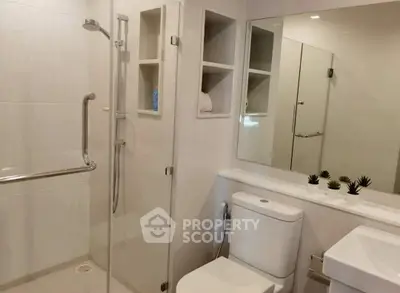 Modern bathroom with glass shower, sleek fixtures, and minimalist decor.