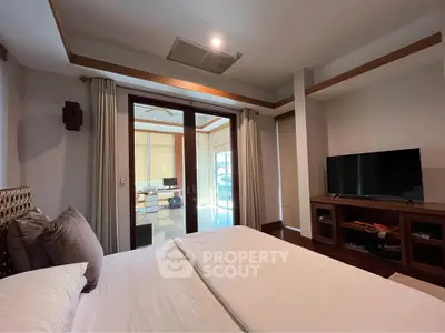 Spacious bedroom with modern decor and large windows for natural light