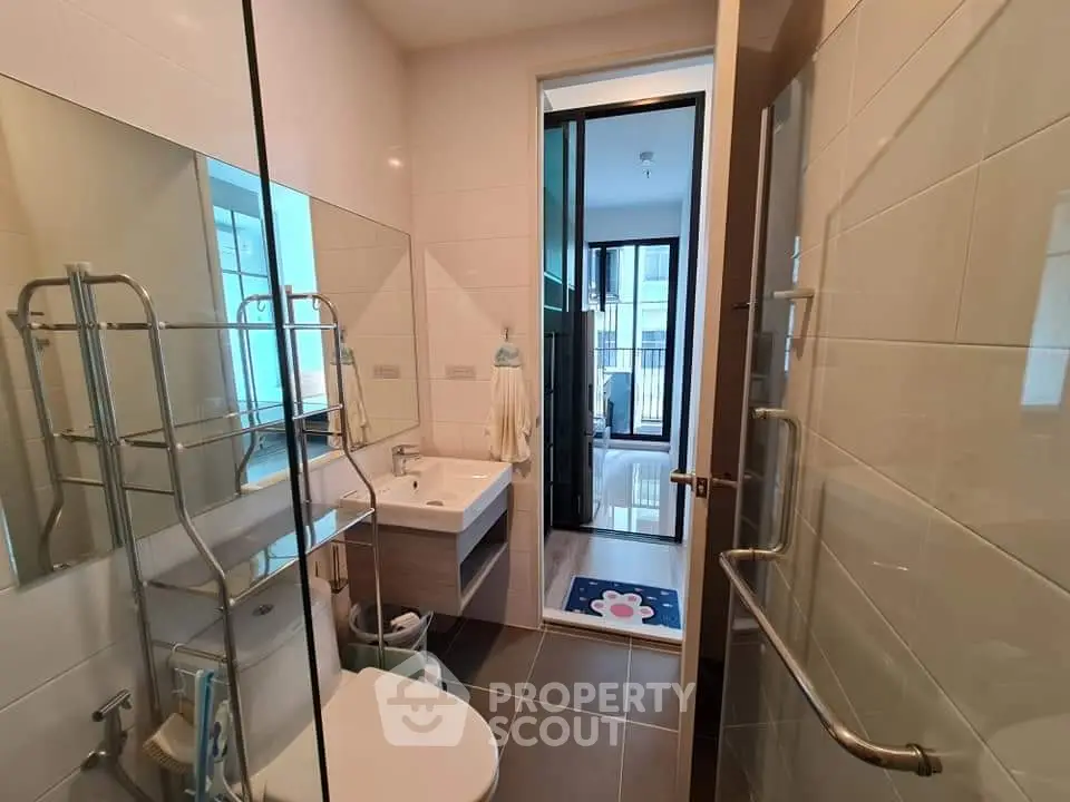 Modern bathroom with sleek fixtures and large mirror in a contemporary apartment.