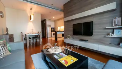 Modern living room with open kitchen, stylish decor, and wooden flooring in a contemporary apartment.
