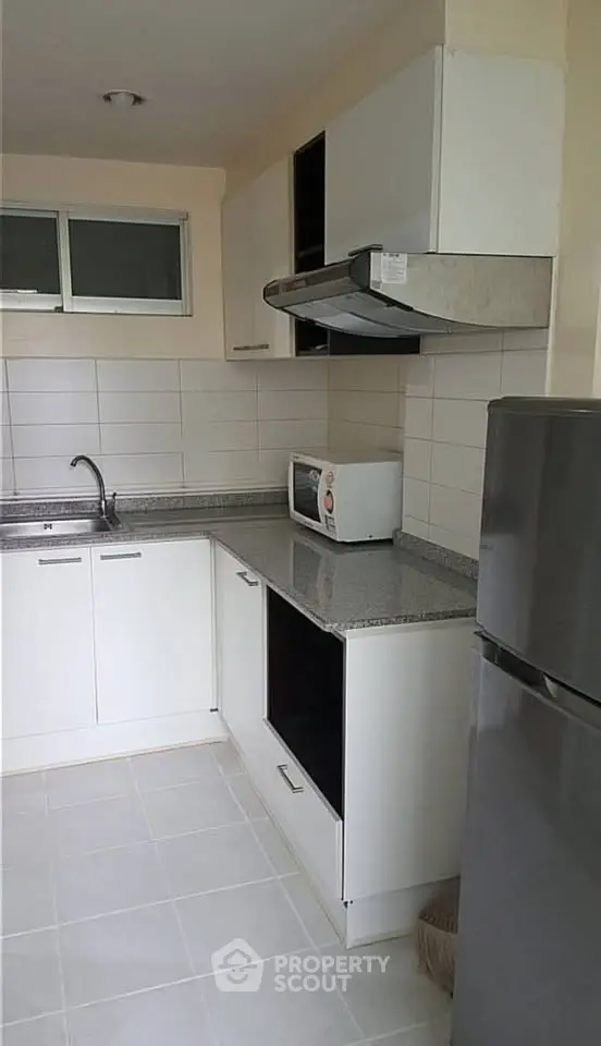 Modern kitchen with sleek white cabinets, granite countertops, and stainless steel appliances.