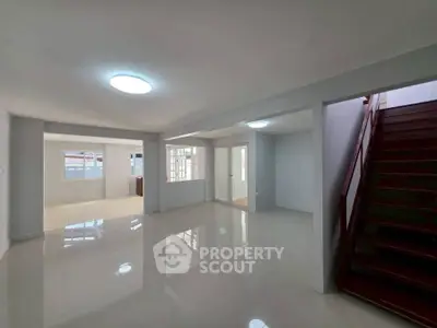 Spacious open-plan living area with modern staircase and ample natural light.