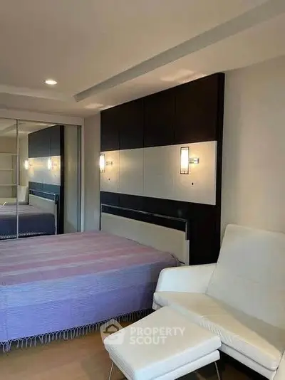 Modern bedroom with stylish decor and mirrored wardrobe doors