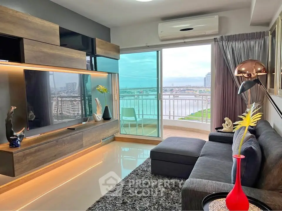 Modern living room with large TV, stylish decor, and balcony with stunning city view.
