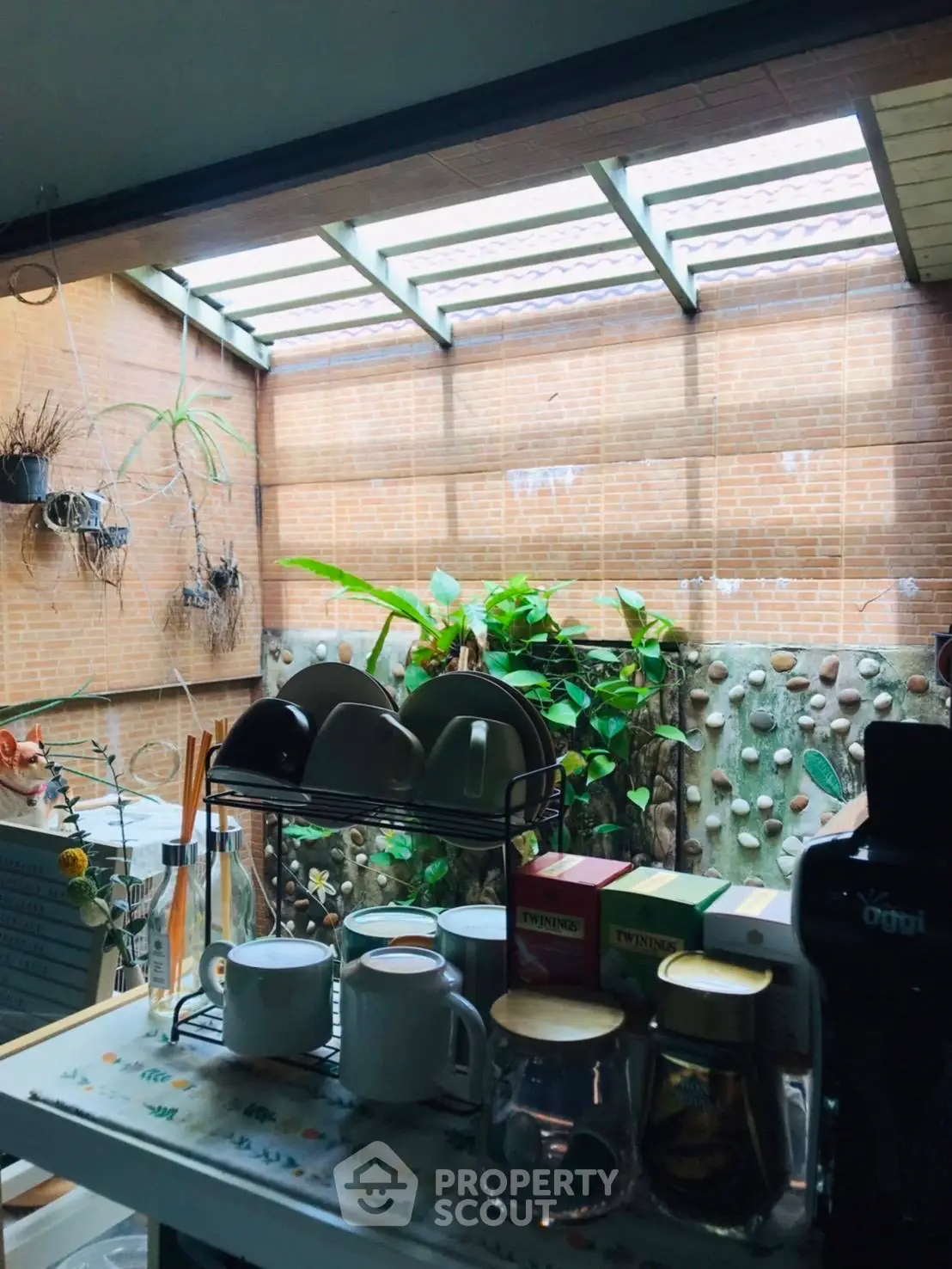 Charming kitchen with garden view and natural light, featuring a cozy tea setup and modern appliances.