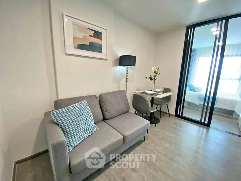 Modern living room with cozy sofa and stylish decor adjacent to a bedroom.