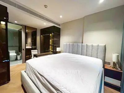 Luxurious bedroom with ensuite bathroom and modern furnishings in a high-end apartment.