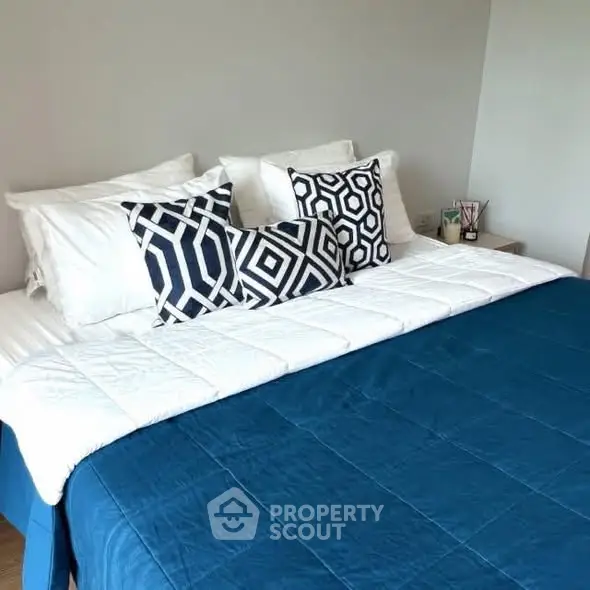 Modern bedroom with stylish geometric pillows and cozy blue bedding