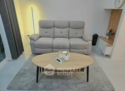 Modern living room with cozy sofa and stylish coffee table in elegant interior design.