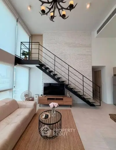 Modern living room with high ceiling, stylish staircase, and elegant decor in a contemporary apartment.