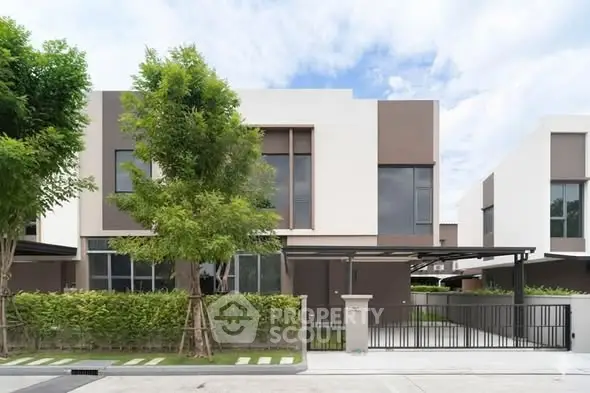 Modern two-story house with sleek design and lush greenery