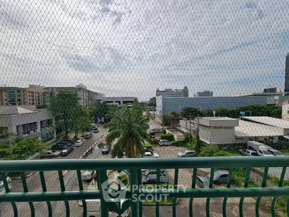 Urban view from a balcony with cityscape and parking area