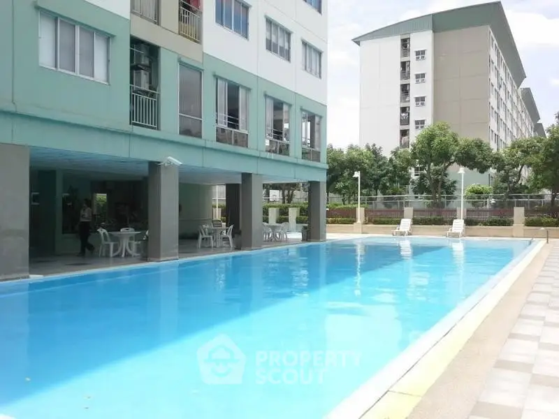 Modern apartment complex with inviting outdoor pool and lounging area.