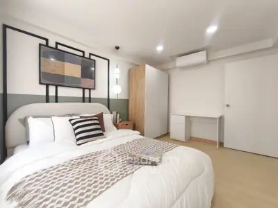 Modern bedroom with stylish decor and cozy bedding in a well-lit space.