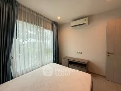 Cozy bedroom with large window and air conditioning in modern apartment