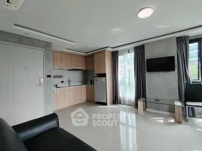 Modern living room with open kitchen, sleek furniture, and large windows for natural light.