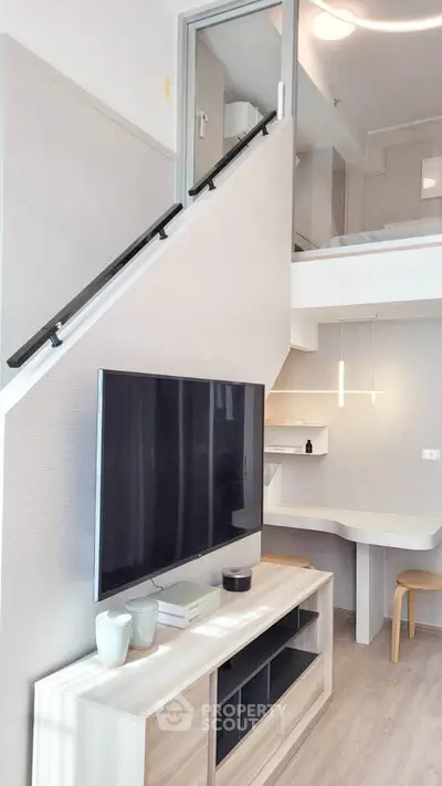 Modern loft-style living room with sleek TV setup and stylish decor