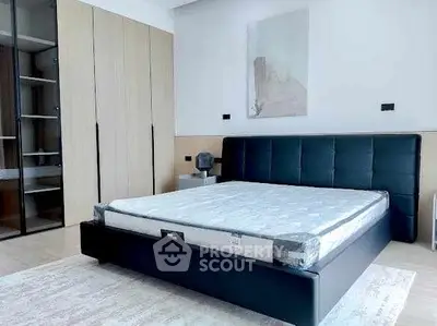 Modern bedroom with sleek black bed and spacious wardrobe