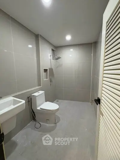 Spacious modern bathroom with sleek fixtures and neutral tiles, perfect for a contemporary home.