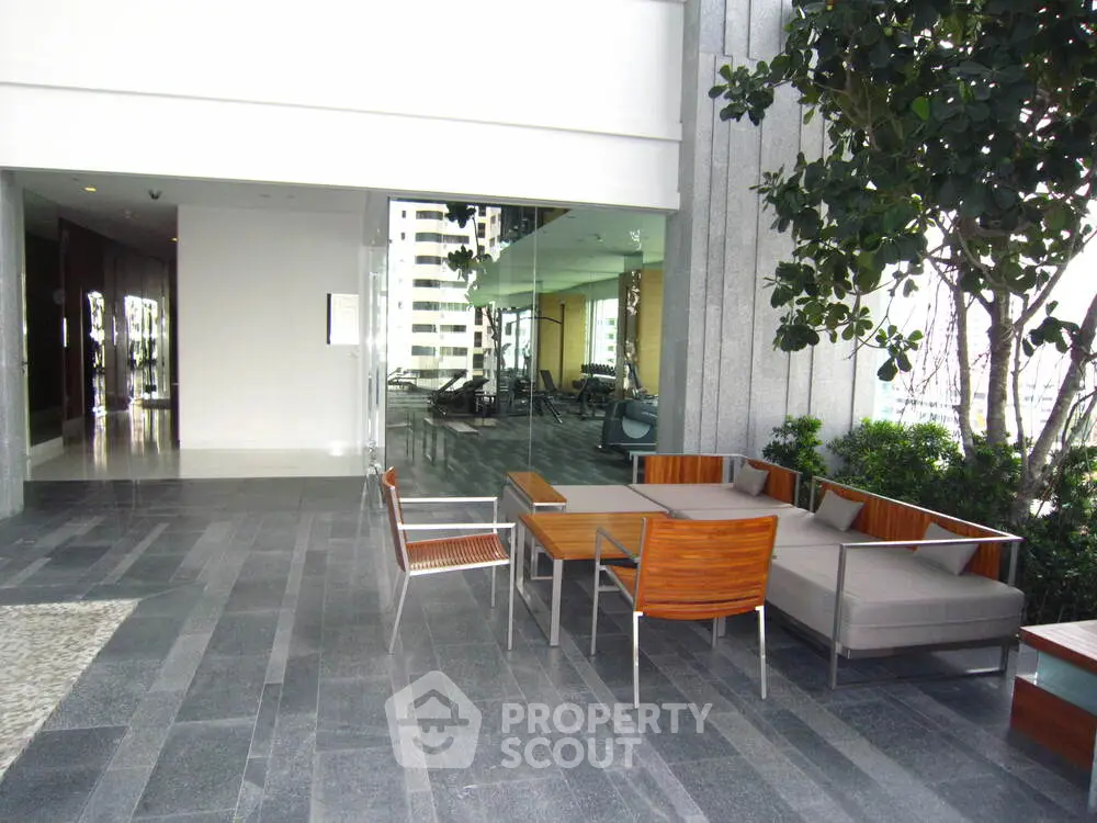 Modern outdoor seating area with sleek furniture and gym view