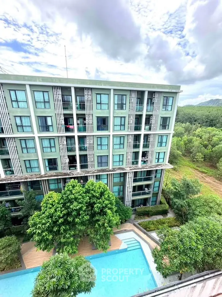Modern apartment building with pool and lush greenery, offering serene views and contemporary living.