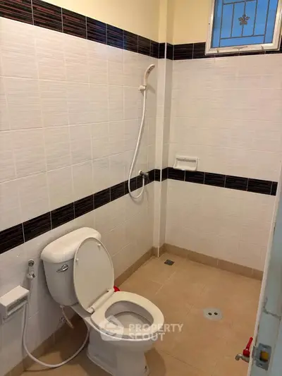 Spacious bathroom with modern shower and toilet in a well-lit setting.