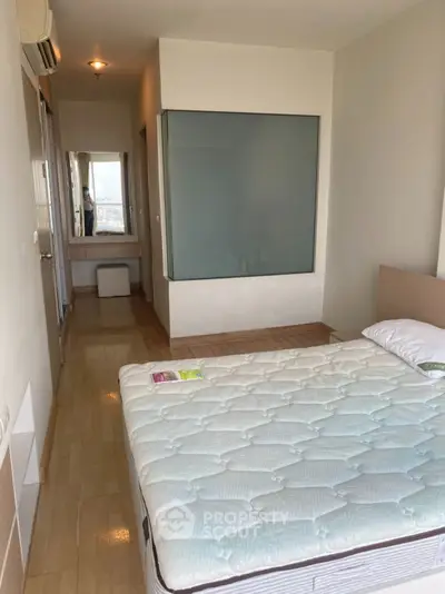 Spacious bedroom with modern design and large window for natural light.