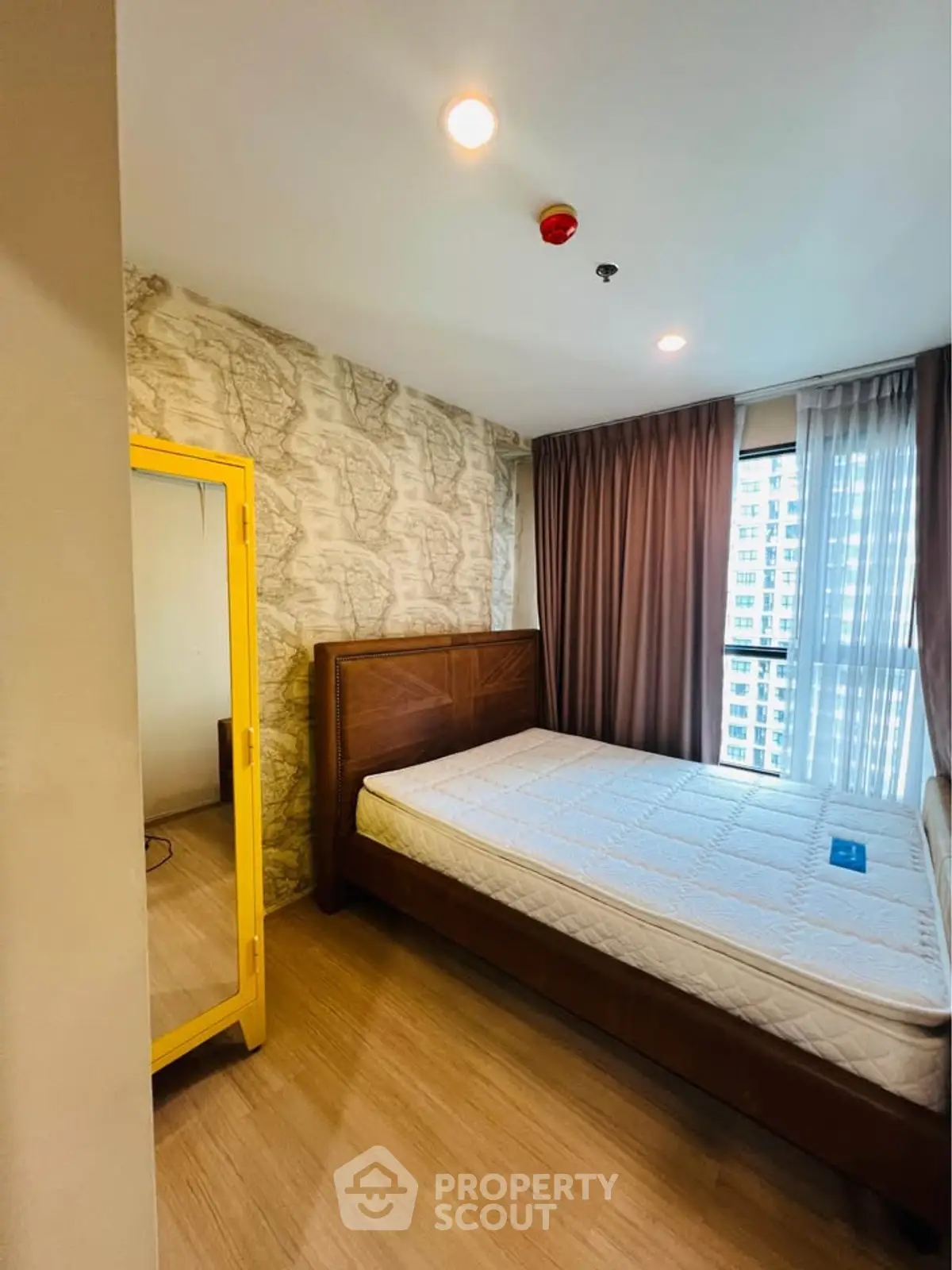 Cozy bedroom with large window and stylish decor in modern apartment