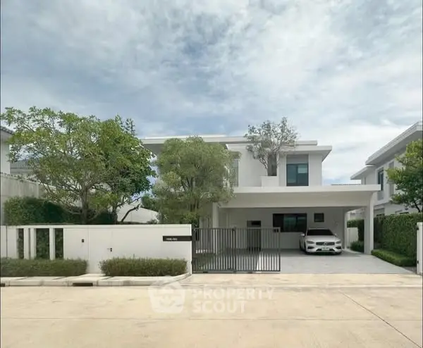 Modern two-story house with driveway and lush greenery