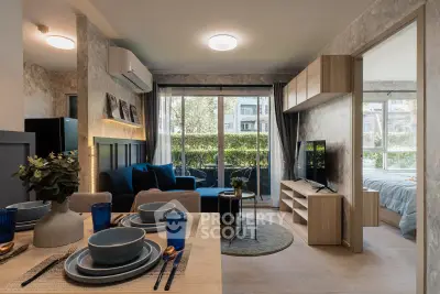 Modern open-plan living room with dining area and large windows overlooking greenery.