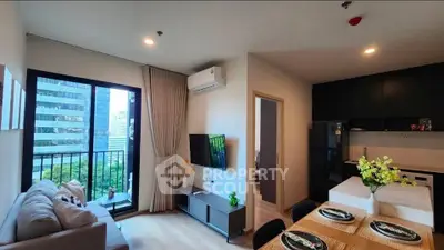 Modern living room with open kitchen, featuring a cozy sofa, wall-mounted TV, and dining area with city view.